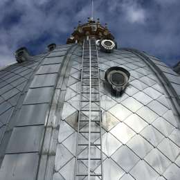 Bended lifeline system on ladder for roof access on a church dome Curved lifeline system used with a ladder on a church roof dome.